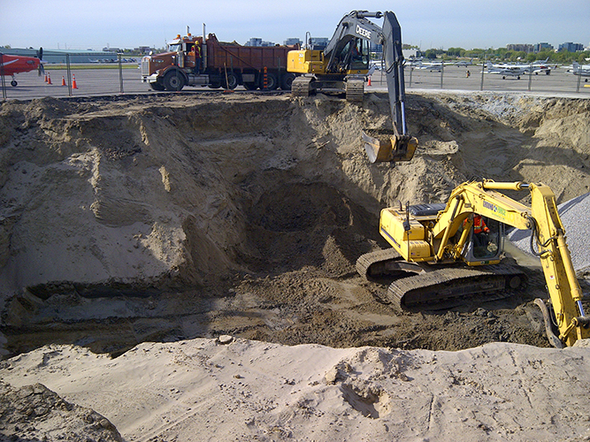 2 excavators digging a hole
