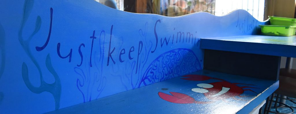 "Just Keep Swimming" Slogan on kids Bench at Hamilton Ronald McDonald House Water themed playroom
